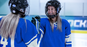 Two female hockey players fist bumping